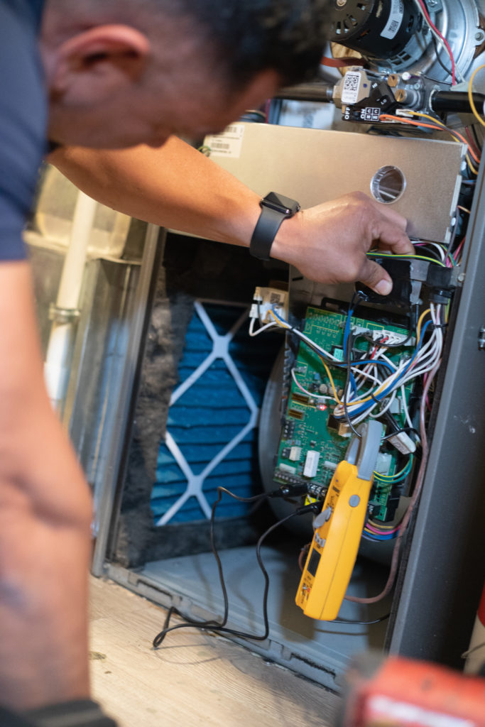 A technician performing a service on a heating system.