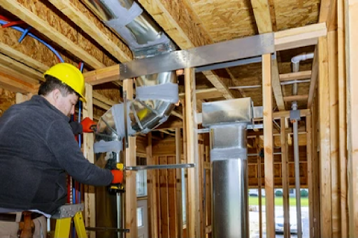 An HVAC tech words on a new duct installation.